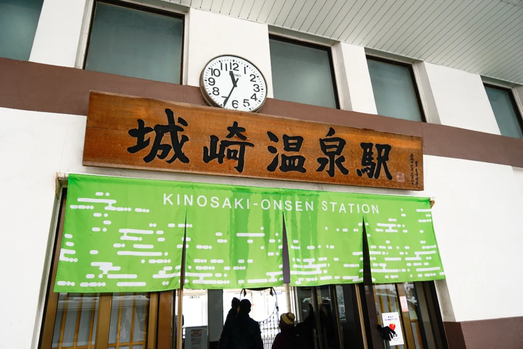 城崎溫泉車站門口的綠色暖簾與時鐘,記錄旅程的起點。