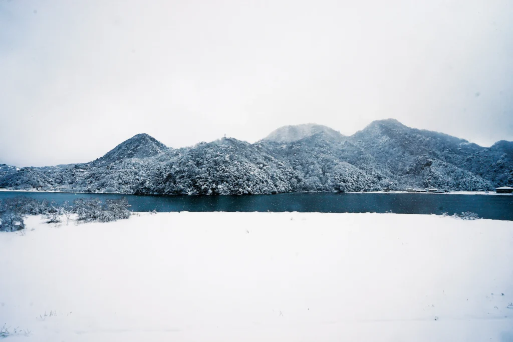 城崎圓山川遠景,水墨畫般的湖泊與被雪覆蓋的山脈。