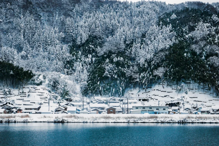 城崎圓山川雪景與遠方山脈，呈現水墨畫般的風景。